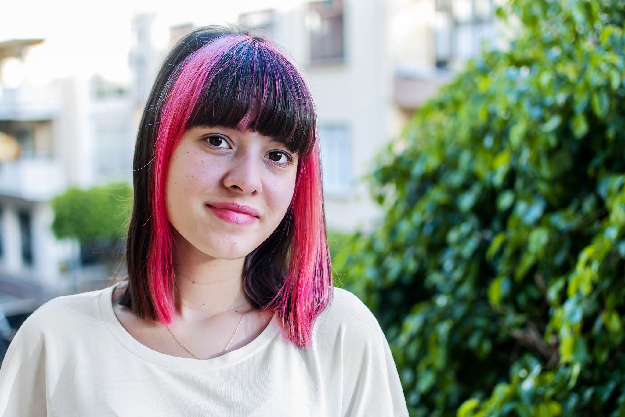 Teenager with pink hair looking at the camera.